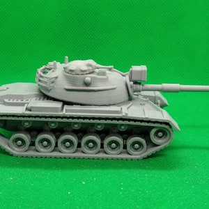 May include: A gray plastic model of a tank with a long barrel and a detailed turret. The tank has a series of wheels on each side and a track.