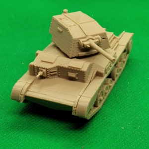 May include: A beige plastic model of a British light tank with a turret and a cannon. The tank is on a green surface.