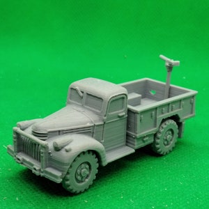 Puede incluir: Un modelo gris de un camión militar vintage con una plataforma y una antena levantada. El camión tiene una cabina detallada y una cama de madera.