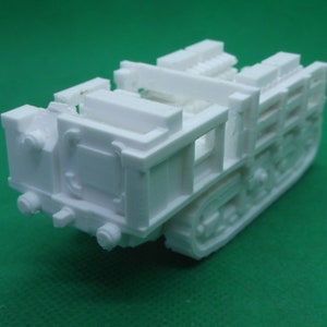 Puede incluir: Modelo de vehículo de orugas de plástico blanco con un interior detallado y una plataforma elevada en la parte trasera.