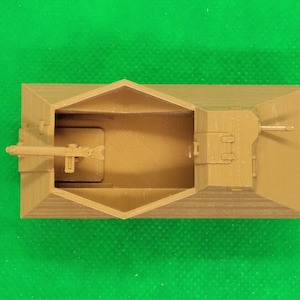 May include: A tan-colored plastic model of a military vehicle with a gun turret and a cannon. The model is detailed with a textured surface and is viewed from above.