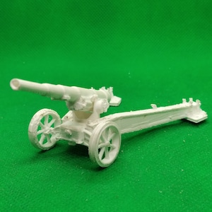 Puede incluir: Un modelo de plástico blanco de un cañón de artillería de la Segunda Guerra Mundial con ruedas y un cañón largo.