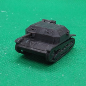 May include: A black toy tank model with a detailed design. The tank has a raised gun turret and tracks.