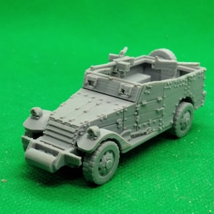 Puede incluir: Un modelo gris detallado de un coche blindado militar con una ametralladora montada en la parte superior. El coche tiene una superficie texturizada y está hecho de plástico.