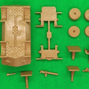May include: A brown plastic model kit of a vehicle with multiple parts, including a chassis, wheels, and a gun turret. The kit is unassembled and ready to be built.