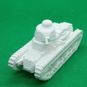 May include: A white plastic model of a French Char B1 tank. The tank has a turret with a gun and a large, rounded front hull.
