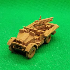 May include: A brown plastic model of a military truck with a gun mounted on the back. The truck has a flatbed and a canvas top. The gun is pointed forward.