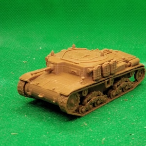 以下が含まれることがあります： ベージュ色の戦車の詳細なモデル。キャタピラと砲塔の複雑なディテールが特徴です。ミニチュアの車両は緑色の背景に配置され、そのデザインが際立っています。コレクションアイテムです。