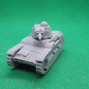 Op de afbeelding: Een grijs plastic model van een Franse tank. De tank heeft een toren met een kanon en een koepel bovenop. De tank staat op een groene ondergrond.