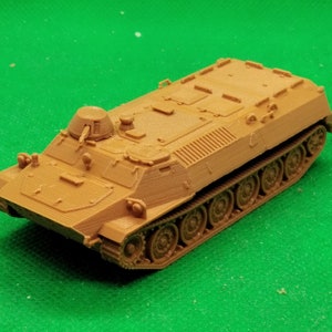 Può includere: Un modello in plastica marrone di un trasporto truppe corazzato militare con una torretta in cima. Il modello è dettagliato ed è realizzato in plastica resistente.