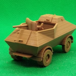 May include: A brown plastic model of a military armored car with a rotating turret and a cannon. The car has four wheels and is on a green surface.