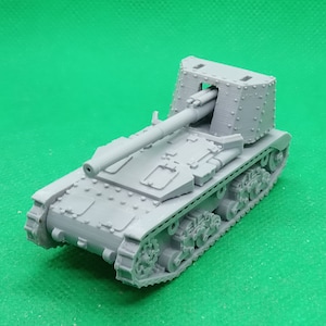 May include: A gray plastic model of a self-propelled artillery gun with a long barrel and tracks. The gun is on a green surface.