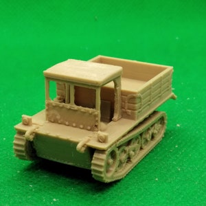 May include: A beige plastic model of a tracked vehicle with a flatbed truck bed. The vehicle has a cab with a windshield and a rear door. The model is detailed with rivets and other features.