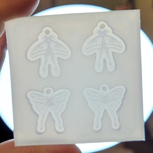 May include: A clear silicone mould with four impressions of a moth with outstretched wings. The mould is designed for making resin jewellery.
