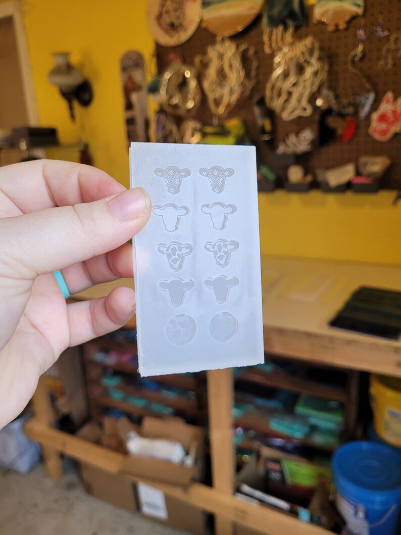 Peut inclure: Un moule en silicone transparent avec huit formes de t&ecirc;te de vache et deux formes rondes. Le moule est con&ccedil;u pour la fabrication d'objets en r&eacute;sine.
