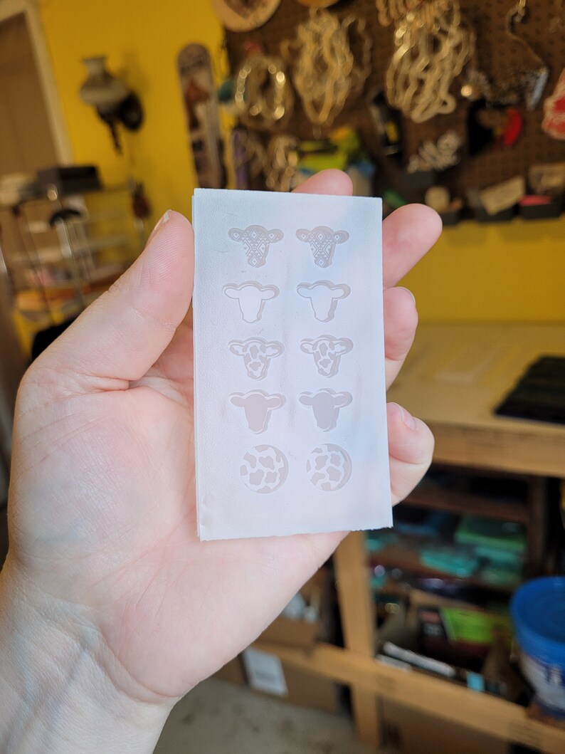 Peut inclure: Un moule en silicone blanc avec six cavit&eacute;s en forme de vache et deux cavit&eacute;s rondes avec un motif de vache. Le moule est con&ccedil;u pour la fabrication d'objets en r&eacute;sine.