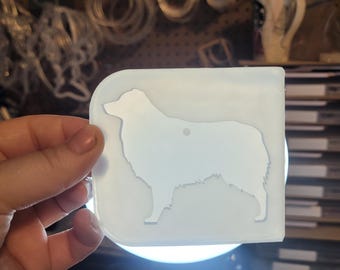 May include: A white silicone mold for resin casting, featuring the silhouette of an Australian Shepherd dog.