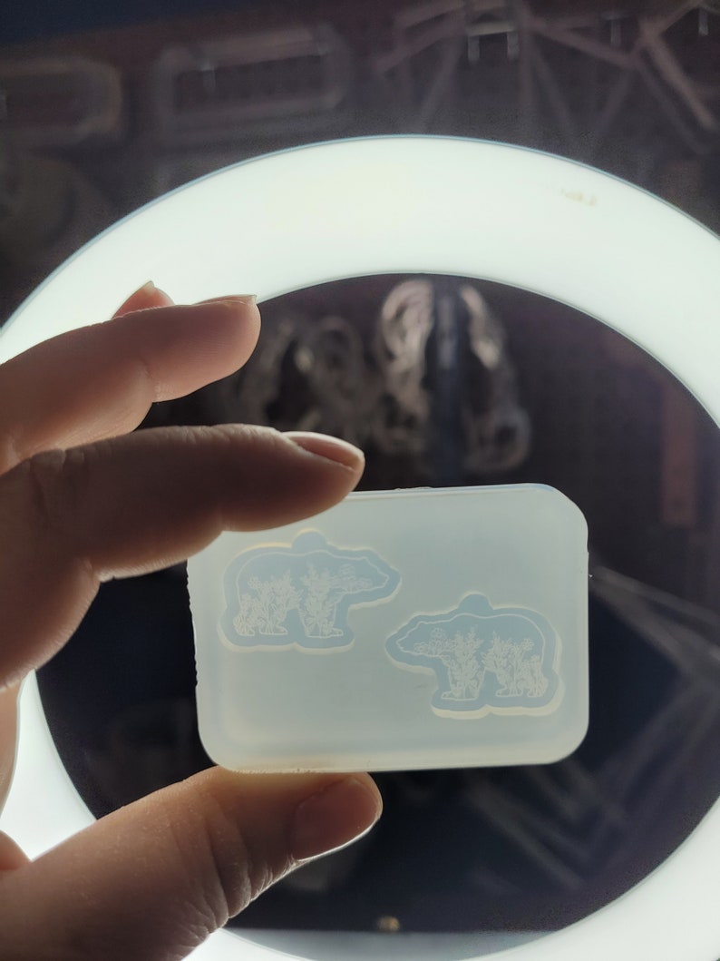 May include: A rectangular, translucent silicone mould featuring two bear-shaped cavities. Each bear cavity is embossed with a detailed, intricate floral pattern throughout the body, designed for casting small decorative items or resin crafts.
