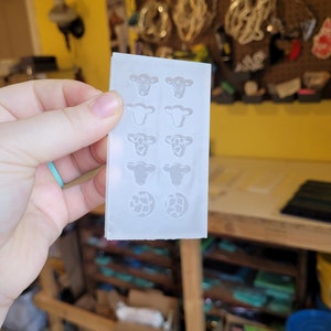 Peut inclure: Un moule en silicone blanc avec huit motifs de t&ecirc;te de vache et deux motifs d'impression de vache. Le moule est con&ccedil;u pour la fabrication d'artisanat en r&eacute;sine.