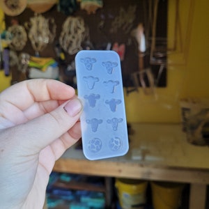 Peut inclure: Un moule en silicone transparent avec huit cavit&eacute;s. Les cavit&eacute;s sont en forme de t&ecirc;tes de vache et de ballons de football.