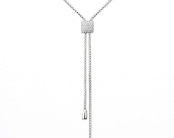 Peut inclure: Un collier en chaîne argent avec un pendentif carré serti de petites pierres claires. Le collier a deux longueurs réglables.