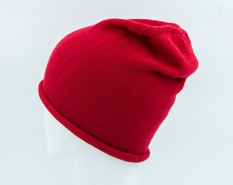 May include: A solid red knit beanie hat. The hat is folded down on one side.