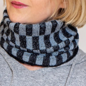 May include: A black and light blue checkered knit neck warmer. The neck warmer is made of a soft, comfortable fabric and is perfect for keeping warm in the winter.