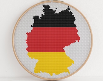 May include: A circular embroidery hoop featuring a cross-stitch design of the German flag in the shape of the country's outline.