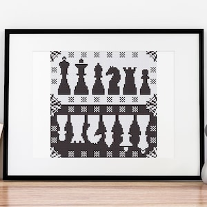 Pode incluir: Bordado em ponto de cruz preto e branco emoldurado que representa peças de xadrez. A fila superior apresenta um rei, uma rainha, duas torres e um bispo. A fila inferior apresenta um peão, um cavalo e dois peões.