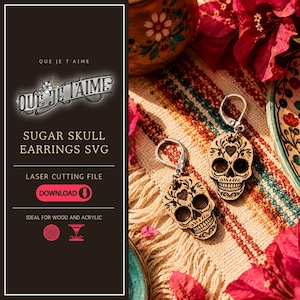 May include: A pair of laser-cut wooden sugar skull earrings with intricate filigree patterns and silver-toned lever-back hooks. The text on the left panel reads QUE JE T'AIME, SUGAR SKULL EARRINGS SVG, LASER CUTTING FILE, and DOWNLOAD.