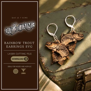 May include: A pair of dangling earrings featuring laser-cut wooden rainbow trout fish shapes with detailed engraved scales and fins. The fish are attached to silver-toned metal lever-back ear wires. The design includes text reading QUE JE T'AIME.