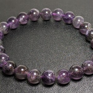 May include: A purple amethyst gemstone bracelet with round beads.
