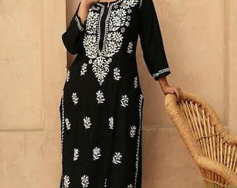 May include: A black long-sleeved kurta with white embroidery featuring floral patterns. The kurta has a V-neckline and is paired with white trousers.