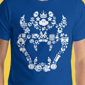 May include: A blue t-shirt with a white design of various Super Mario Bros. characters and items, including a Goomba, a Koopa Troopa, a Super Mushroom, and a Starman.