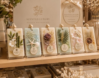 May include: A selection of rectangular botanical wax candles, each adorned with natural elements like flowers and shells. The candles are displayed with hotel branding. The collection is part of a 'Scented Luxury' range.
