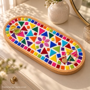 May include: An oval wooden tray featuring a vibrant mosaic pattern made of small, multi-colored geometric tiles in shades of red, orange, yellow, green, blue, purple, and pink. The center includes a flower-shaped design made of pink and yellow tiles.