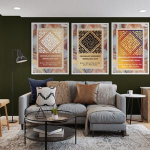 May include: Three framed art prints with gold geometric designs and Arabic calligraphy. The prints have a marble-like background and are displayed above a gray sofa with decorative pillows. The room has a modern aesthetic.