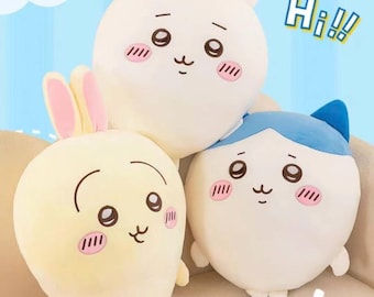 以下が含まれることがあります： 漫画の動物の形をした3つのぬいぐるみ。 ピンクの耳を持つ薄い黄色のウサギ、白いクマ、青いアクセントの白い猫。 それぞれにかわいい顔と頬の赤みがあります。 背景には「Nice」と「Hi!!」の文字があります。