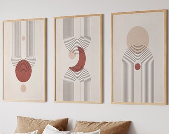 May include: Three abstract art prints with geometric shapes in shades of brown, beige, and red. The prints are framed in natural wood and hung on a white wall above a bed with brown and white bedding.