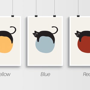 Puede incluir: Tres impresiones de arte minimalistas con un gato negro acostado sobre un c&iacute;rculo. Los c&iacute;rculos son amarillo, azul y rojo. Las impresiones est&aacute;n etiquetadas como "Amarillo", "Azul" y "Rojo".