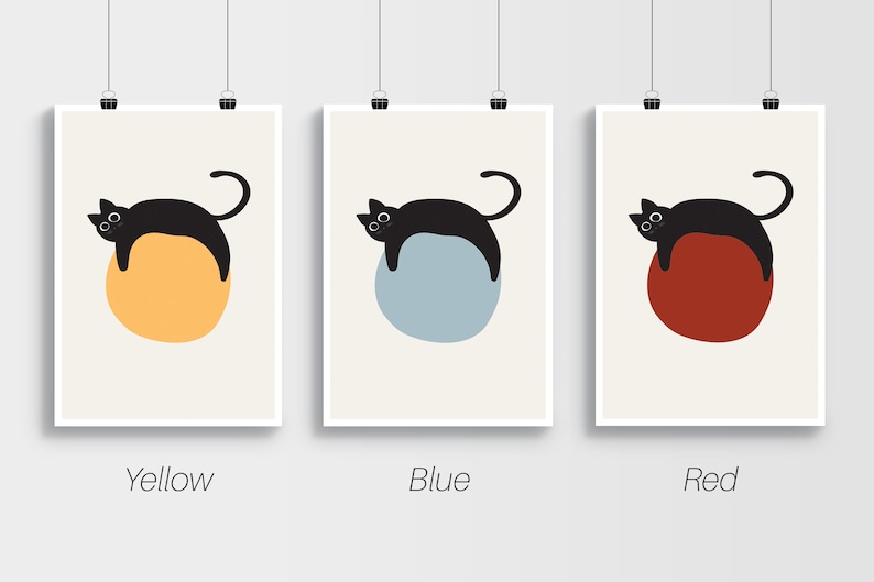 Puede incluir: Tres impresiones de arte minimalistas con un gato negro acostado sobre un c&iacute;rculo. Los c&iacute;rculos son amarillo, azul y rojo. Las impresiones est&aacute;n etiquetadas como "Amarillo", "Azul" y "Rojo".