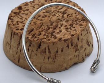 Solid silver slim open torque bangle featuring wire wrapped ends detail hallmarked