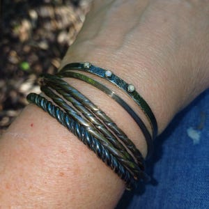 solid silver slim bangle triangular profile stacked with other bangles and bracelets