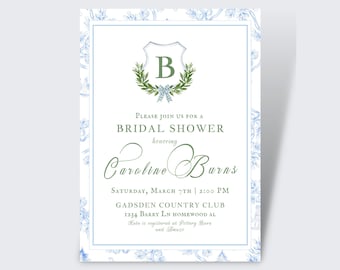 Può includere: Un biglietto bianco con un bordo di design floreale blu e bianco. Il biglietto presenta una ghirlanda verde con uno scudo che contiene la lettera "B" al centro. Il testo sul biglietto recita "Si prega di unirsi a noi per una festa di addio al nubilato in onore di Caroline Burns Sabato 7 marzo 14:00 Gadsden Country Club 1234 Barry Ln Homewood AL Kate è registrata presso Pottery Barn e Amazo".