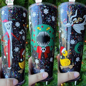 May include: Three black glitter tumblers with different Nightmare Before Christmas characters. The first tumbler features Jack Skellington, the second features Oogie Boogie, and the third features Zero the ghost dog.
