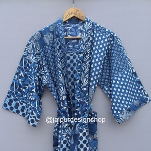 Op de afbeelding: Een blauwe en witte katoenen badjas met een strikceintuur. De badjas heeft verschillende geometrische en bloemmotieven. De tekst "@jaipurdesignshop" is op de badjas gedrukt.