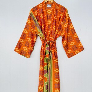 May include: Orange, green, and purple patterned kimono robe with a tie belt. The tag on the robe reads "NR 720".