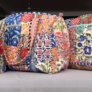 Puede incluir: Tres bolsas de tela de patchwork coloridas con patrones florales y ribetes contrastantes. Las bolsas están hechas de tela acolchada y tienen un aspecto único y hecho a mano.