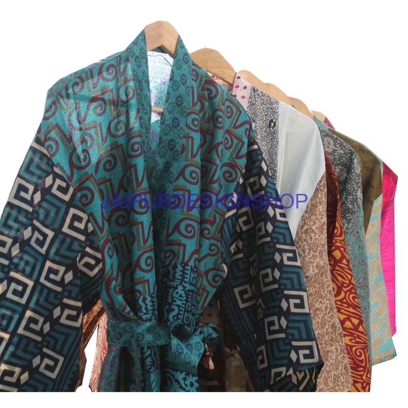 May include: A collection of colorful silk robes with various patterns, including geometric designs and floral motifs. The robes are hanging on wooden hangers.