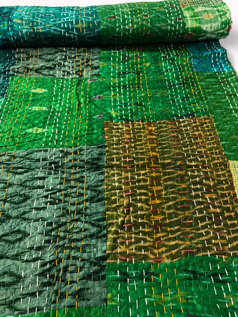 May include: Green and brown patchwork fabric with a quilted texture. The fabric is made of silk and has a subtle sheen.